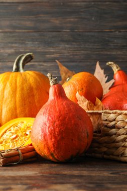 Ahşap arka plan üzerinde saman sepeti içinde Kabaklar, kopya alanı