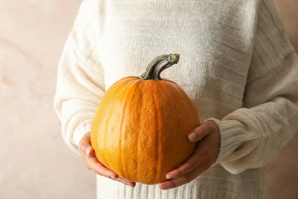 Young woman holding pumpkin on brown background, copy space — Stock fotografie