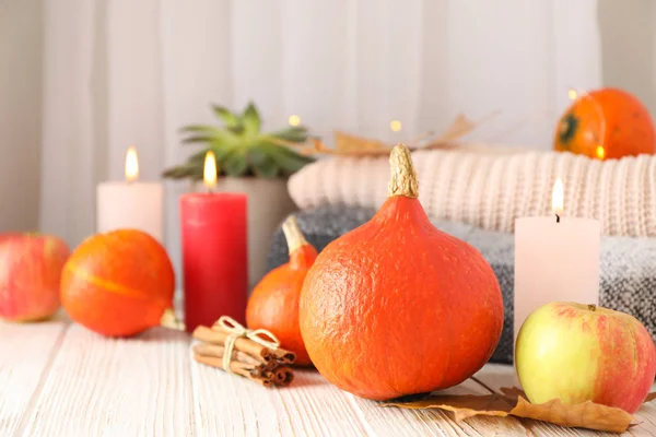 Pumpkins, clothes, leaves and candles on wooden background, copy — Stock Photo, Image