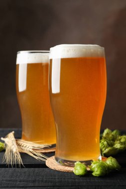 Ahşap masa üzerinde bira, hop konileri ve sivri ler ile Gözlük, boşluk