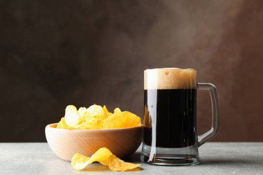 Gri masada bir bardak koyu bira ve cips, metin için alan