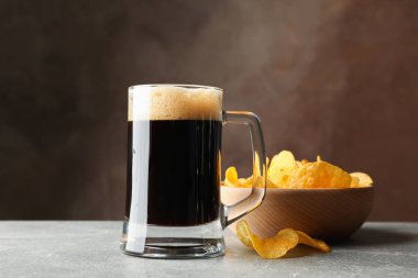 Gri masada bir bardak koyu bira ve cips, metin için alan
