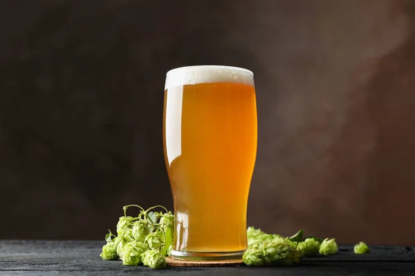 Glas Bier und Hopfenzapfen auf Holztisch, Kopierraum — Stockfoto