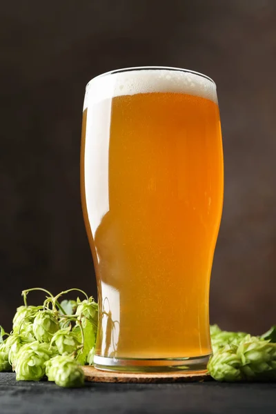 Glas öl och humlekottar på träbord, kopiera utrymme — Stockfoto