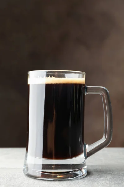 Стакан тёмного пива на сером столе, место для текста — стоковое фото