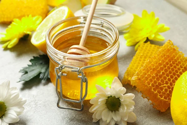 花、レモン、ハニカム、蜂蜜とディッパー付きのガラス瓶 — ストック写真