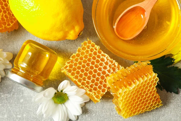 灰色の背景に蜂蜜、花やレモン、クローズアップ — ストック写真