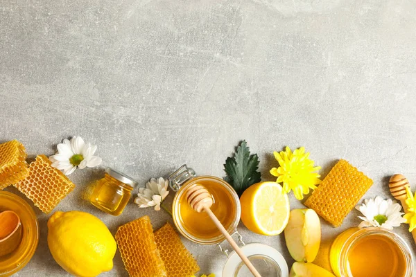 Platte lag met honing, bloemen en fruit op grijze achtergrond, kopiëren — Stockfoto