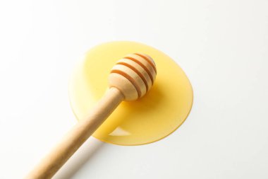 Beyaz arka planda bal birikintisi içinde Dipper, kopya alanı