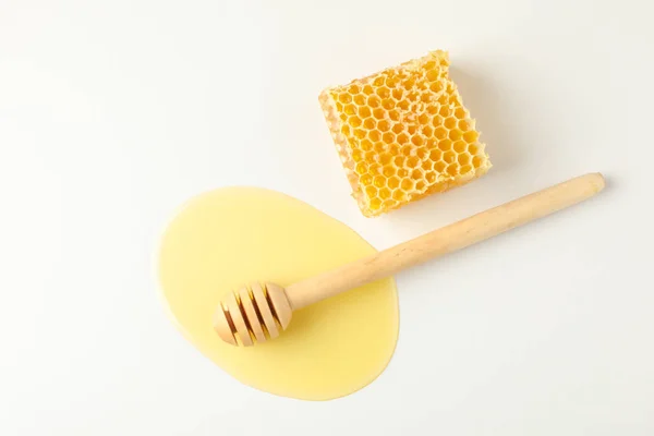 Dipper i pöl av honung och Honeycomb på vit bakgrund, topp — Stockfoto