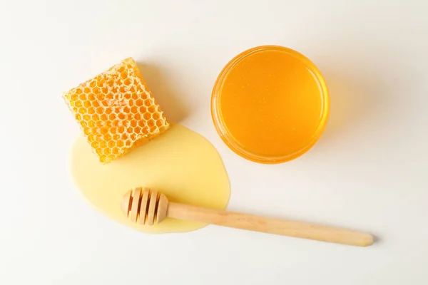 Favo de mel, mergulhador e frasco com mel no fundo branco, parte superior vi — Fotografia de Stock