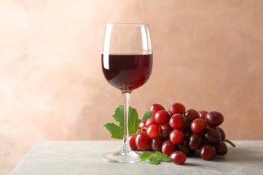 Üzüm ve gri arka plan üzerinde şarap ile cam, metin için alan