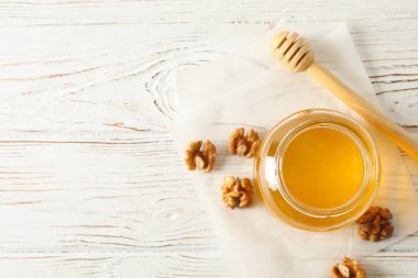 Beyaz bac üzerinde bal ile ceviz, dipper, parşömen ve cam kavanoz
