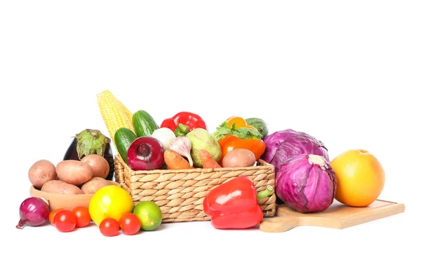 Wicker basket, wood board and vegetables isolated on white backg — Stock Photo, Image