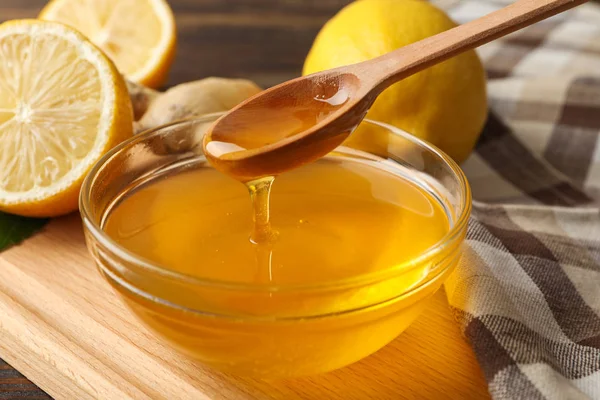 Limones, tazón con miel y cazo sobre fondo de madera, cerca u Fotos de stock libres de derechos