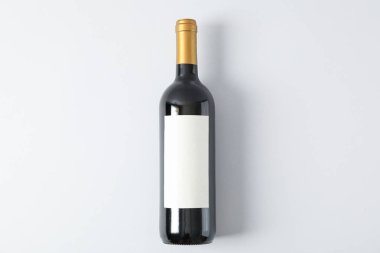 Gri arka planda kırmızı şarap şişesi, metin için alan