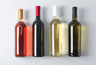 Gri arka planda farklı şarap içeren şişeler, üst görünüm