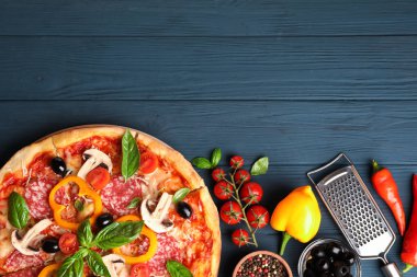 Ahşap arka plan üzerinde lezzetli pizza ve malzemeler, kopya alanı