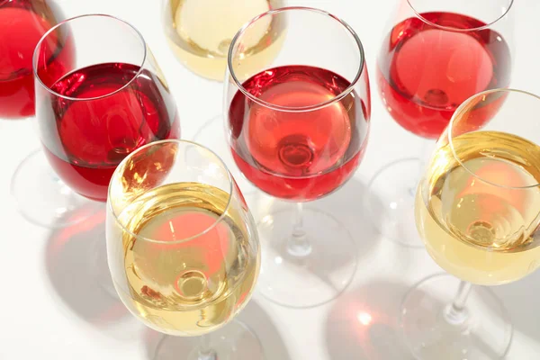 Óculos com diferentes vinhos sobre fundo branco, close-up — Fotografia de Stock