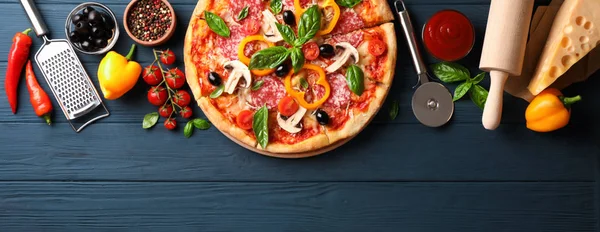 Deliciosa pizza e ingredientes sobre fondo de madera, espacio para copiar — Foto de Stock
