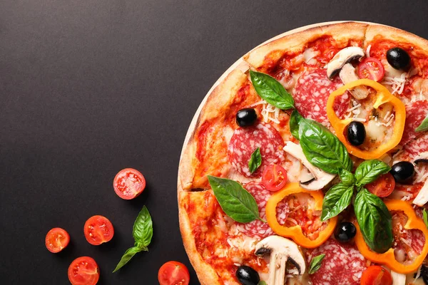Deliciosa pizza y tomates sobre fondo oscuro, espacio para copiar — Foto de Stock