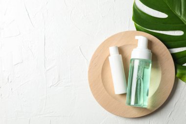 Palmiye yaprağı, ahşap tabak, beyaz bac üzerinde scrub ve krem ile şişe