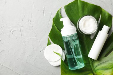 Gri backgr üzerinde vücut bakım aksesuarları ve palmiye yaprağı ile düz yatıyordu