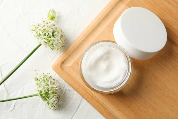 Pot met crème, Allium bloemen en bord op witte achtergrond, om te — Stockfoto