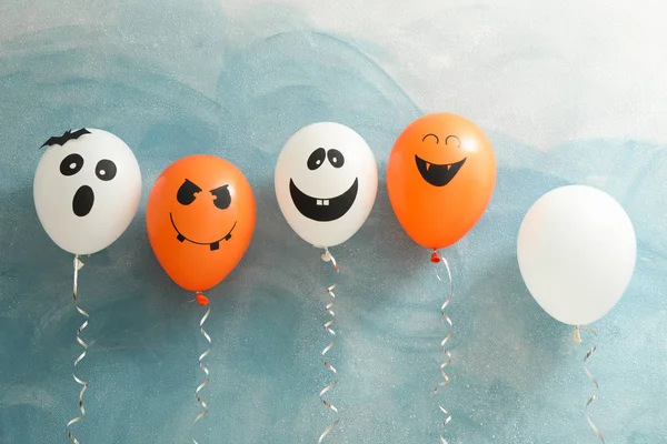 Halloween balloons on color background, space for text