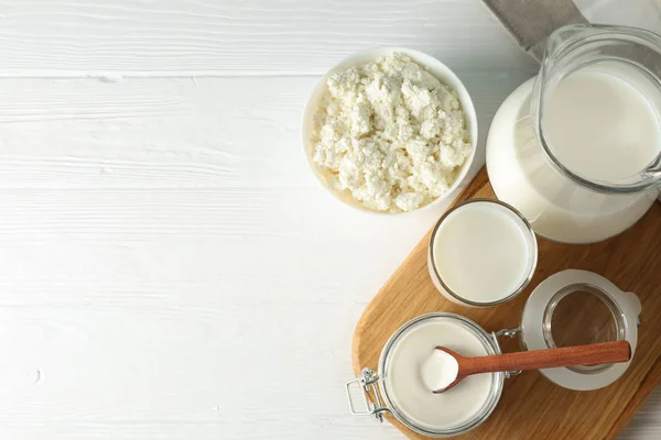 Flach lag. frische Milchprodukte, Brett und Handtuch auf weißem Holz — Stockfoto