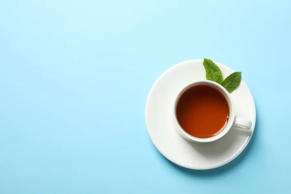Mavi arka planda çay ve nane yaprakları fincan, kopya alanı — Stok fotoğraf