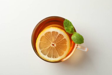 Fincan çay, nane ve limon beyaz arka planda, üstten görünüm