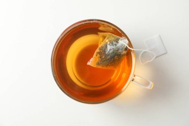 Beyaz arka plan üzerinde çay poşeti ile çay fincanı, üst görünümü