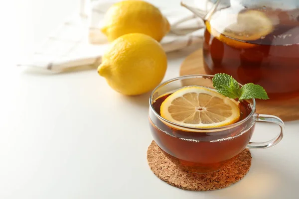 Cup of tea, mint, lemon, tea pot and towel on white background, — Stock Photo, Image