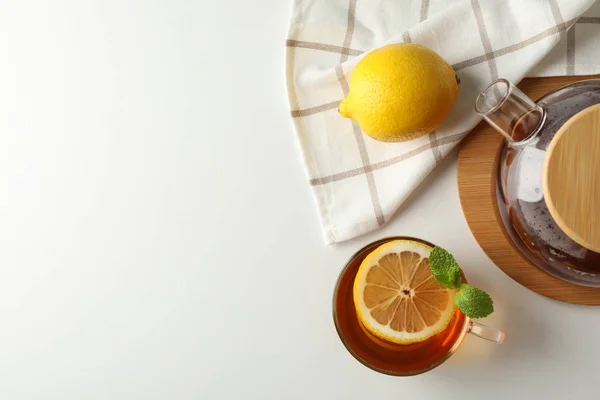 Kopp med te, mynte, sitron, tegryte og håndkle på hvit bakgrunn , – stockfoto