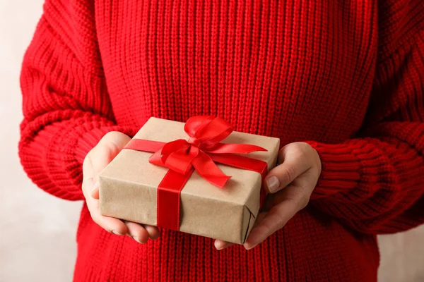 Woman in red sweater holding present with bow, space for text — Stock Photo, Image