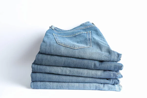 Stack of jeans pants on white background, space for text — Stock Photo, Image