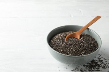 Chia tohumları, ahşap kaşık ve beyaz ahşap arka plan üzerinde kase, kopya