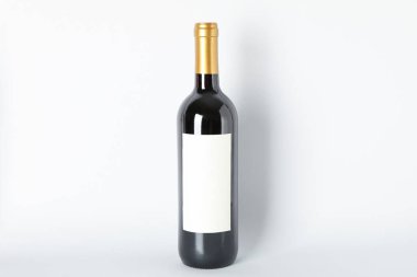 Gri arka planda kırmızı şarap şişesi, metin için alan