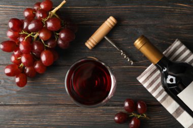 Üzüm, şişe ve ahşap arka plan üzerinde şarap ile cam, üst görünümü