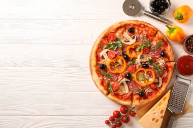 Lezzetli pizza ve beyaz ahşap arka plan üzerinde malzemeler, kopya