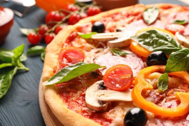 Lezzetli pizza ve ahşap arka plan üzerinde malzemeler, yakın
