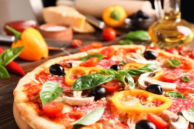 Lezzetli pizza ve ahşap arka plan üzerinde malzemeler, yakın