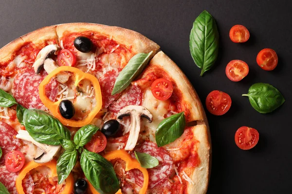 Deliciosa pizza y tomates sobre fondo oscuro, de cerca — Foto de Stock
