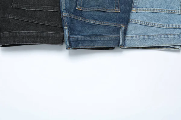 Platte lay met jeans op witte achtergrond, kopieer ruimte — Stockfoto