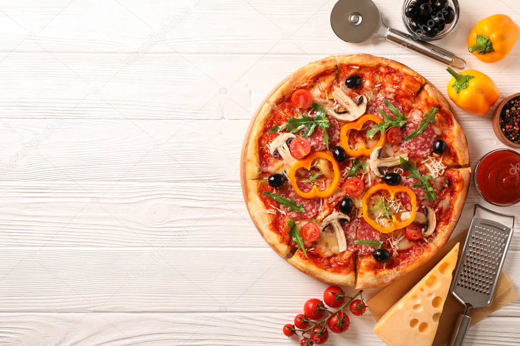 Delicious pizza and ingredients on white wooden background, copy