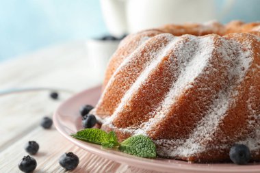 Ahşap arka plan, boşluk üzerinde pudra şekeri ve yaban mersini ile Kek