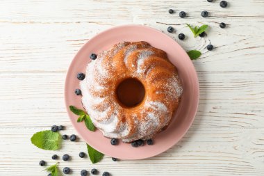 Ahşap arka plan üzerinde pudra şekeri ve yaban mersini ile Kek, üst v