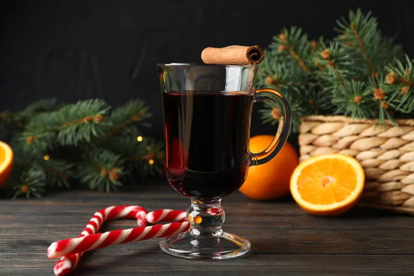 Glass of tasty mulled wine on decorated wooden background, space — Stock Photo, Image