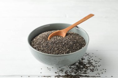 Chia tohumları, ahşap kaşık ve beyaz ahşap arka plan üzerinde kase, kopya